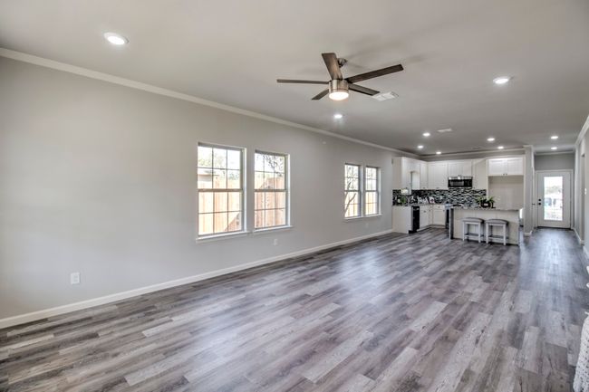 Unfurnished living room with recessed lighting, ornamental molding, ceiling fan, plenty of natural light, and wood finished floors | Image 6