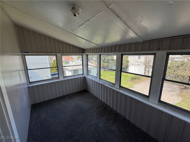 Unfurnished sunroom with carpet floors, lofted ceiling, and plenty of natural light | Image 15