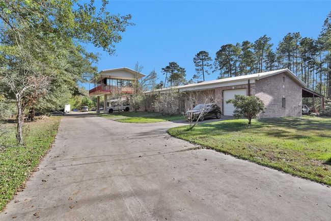 2nd driveway leads you to the 2-car tandem attached garage. Roll up doors on each side. | Image 5