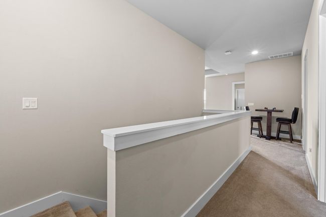 Hall featuring carpet flooring, baseboards, visible vents, recessed lighting, and an upstairs landing | Image 28