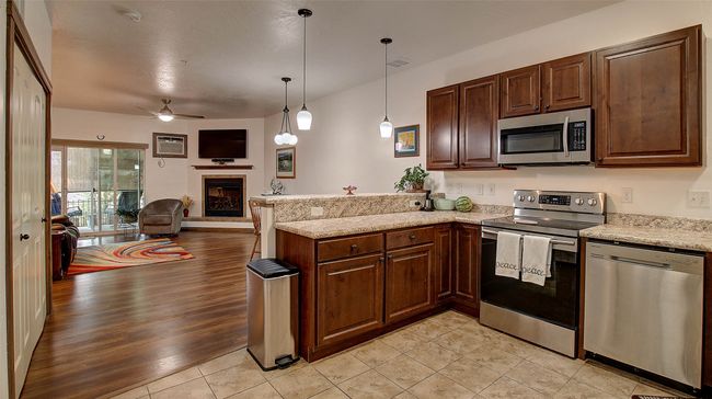 Kitchen with breakfast bar, range, refrigerator, dishwasher, microwave and plenty of storage | Image 18