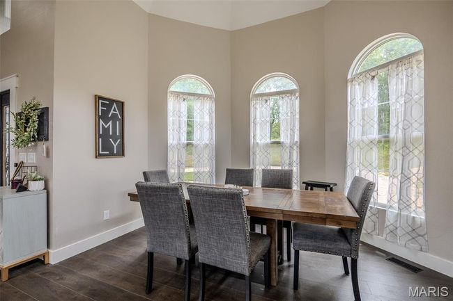 Dining room with a high ceiling and dark wood-style floors | Image 10
