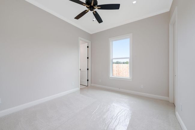 Empty room with light carpet, ceiling fan, and ornamental molding | Image 38