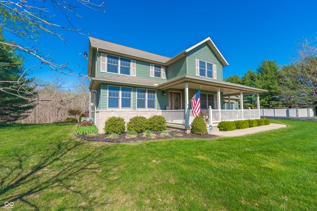 view of front of property with brick siding, a front lawn, fence, and covered porch | Image 35