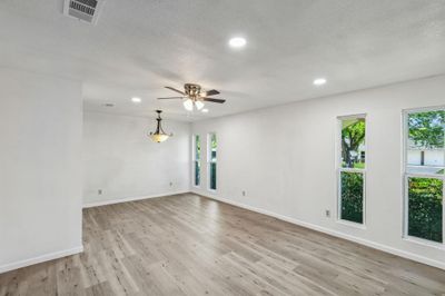 Unfurnished room with light hardwood / wood-style floors, a textured ceiling, and ceiling fan | Image 3