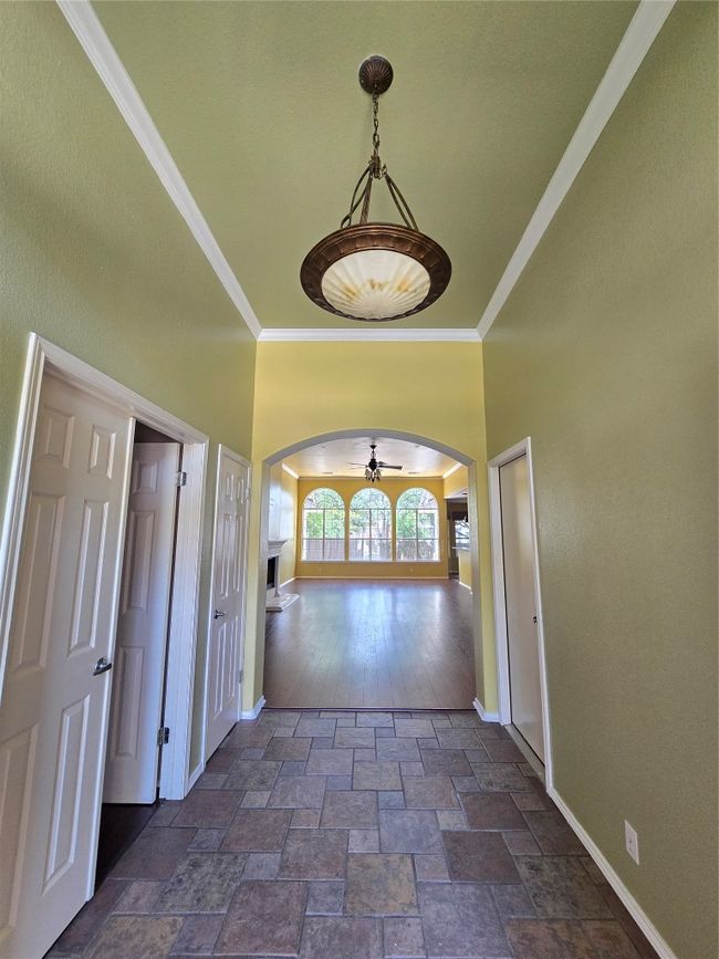 Spare room with arched walkways, crown molding, dark stone finish flooring, and ceiling fan | Image 4