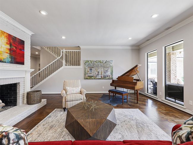 Living room featuring recessed lighting, ornamental molding, a fireplace, and stairs | Image 9