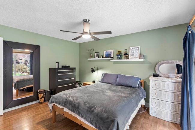 Bedroom with a ceiling fan, wood finished floors, and a textured ceiling | Image 18