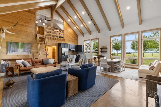 Living area with high vaulted ceiling, recessed lighting, wood walls, beam ceiling, and light tile patterned floors | Image 17