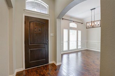 Foyer featuring lofted ceiling, dark hardwood / wood-style floors, and an inviting chandelier | Image 3