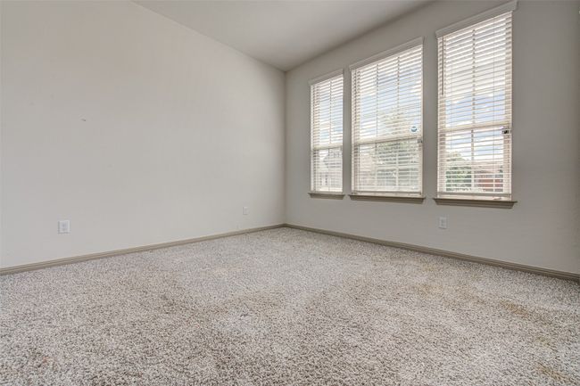 Carpeted empty room with baseboards and lofted ceiling | Image 4