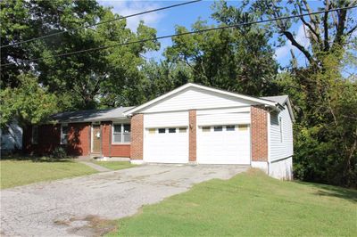 Ranch-style house with Vinyl siding and brick trim on the front. | Image 1