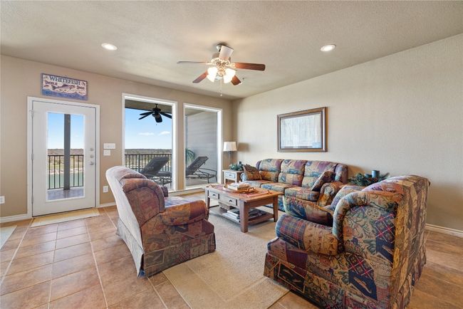 Living room with light tile patterned flooring, ceiling fan, baseboards, and recessed lighting | Image 5