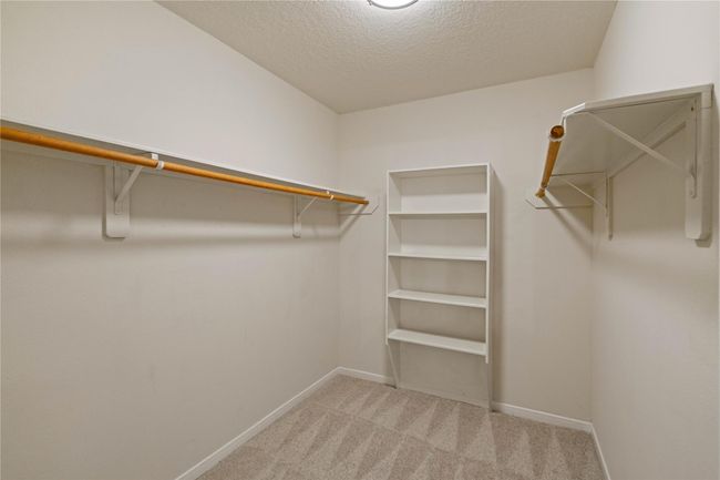 Primary closet with a shelf for shoes. | Image 30