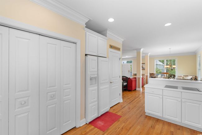 Kitchen featuring ornamental molding, decorative columns, white cabinets, light wood-style flooring, and recessed lighting | Image 8