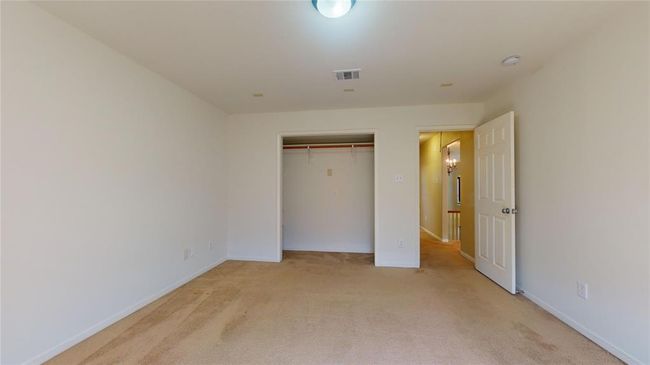 Spacious guest bedroom with ample closet space and soft carpeting, perfect for comfort and relaxation. | Image 36