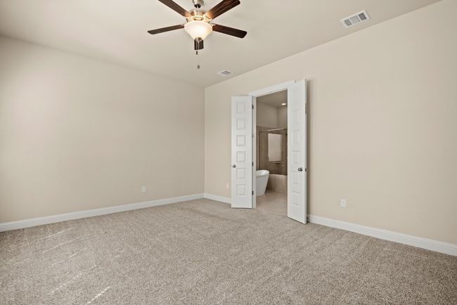 Unfurnished bedroom with light colored carpet, baseboards, a ceiling fan, and visible vents | Image 17