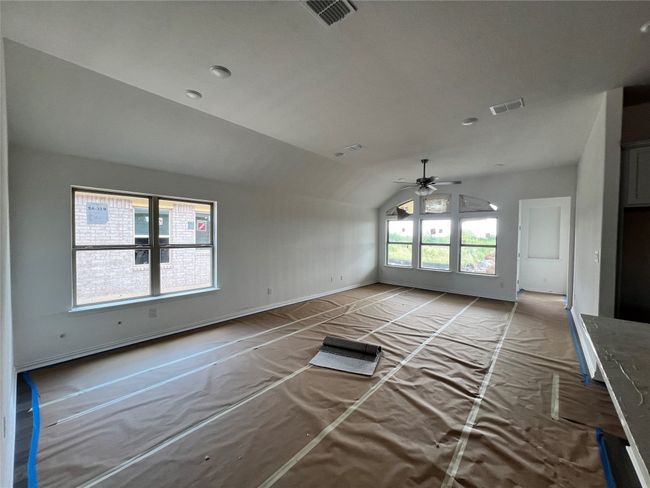 Unfurnished living room with vaulted ceiling and ceiling fan | Image 5
