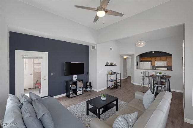 Living room featuring ceiling fan, light wood finished floors, arched walkways, baseboards, and visible vents | Image 15