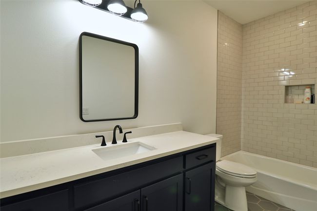 Bathroom with tile patterned flooring, shower / bathing tub combination, toilet, and vanity | Image 17