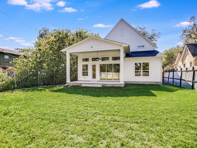 Rear view of property featuring a fenced backyard, a ceiling fan, and a shingled roof | Image 28