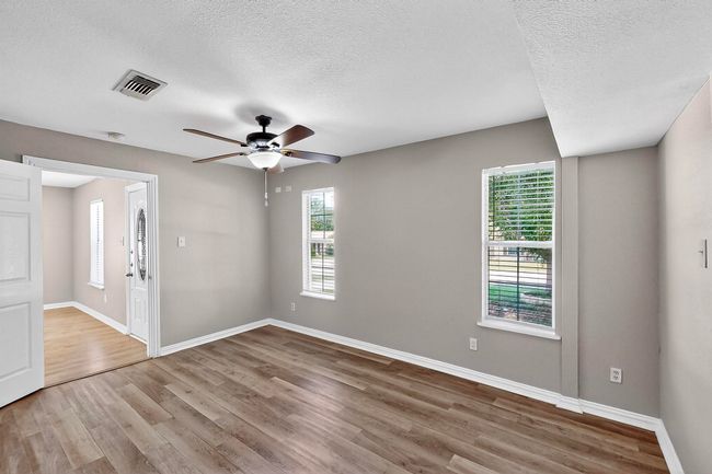 Empty room featuring a ceiling fan, wood finished floors, and a textured ceiling | Image 21