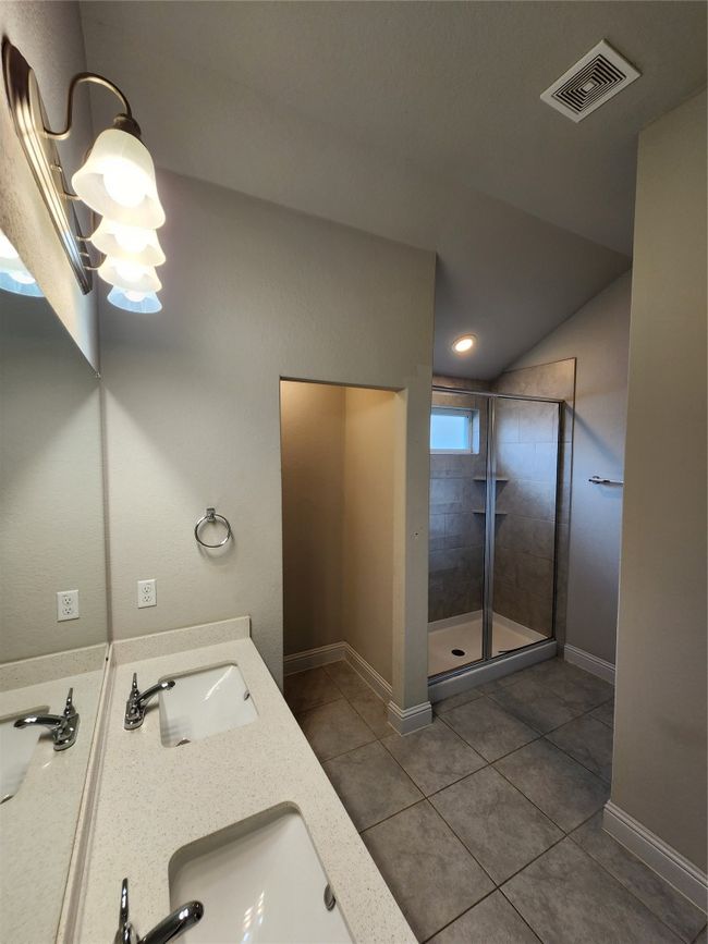 Full bathroom featuring tile patterned floors, tiled shower, double vanity, lofted ceiling, and recessed lighting | Image 12