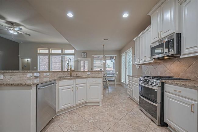 Enjoy a functional layout with the under-mount sink and dishwasher integrated into the breakfast bar, allowing for effortless flow and views across the living and breakfast areas. | Image 10