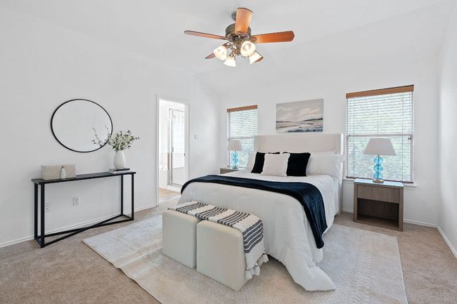 Bedroom with carpet floors, baseboards, ensuite bath, a ceiling fan, and lofted ceiling | Image 16