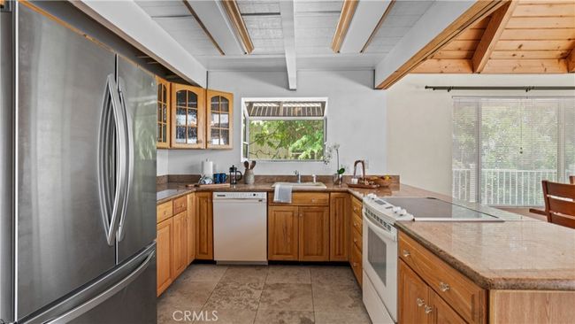 Kitchen features travertine floor tiles, granite counter-tops, a garden window. | Image 12
