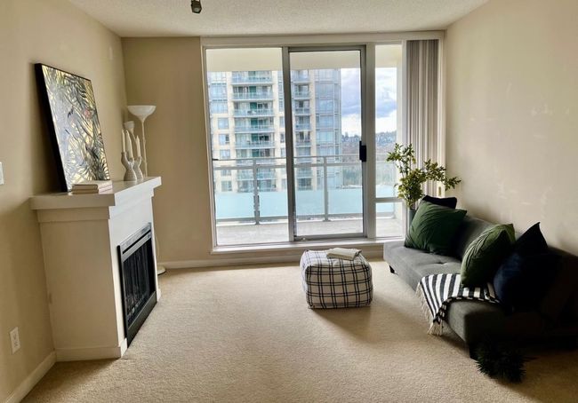 Living room with a fireplace, carpet, baseboards, and a wall of windows | Image 15
