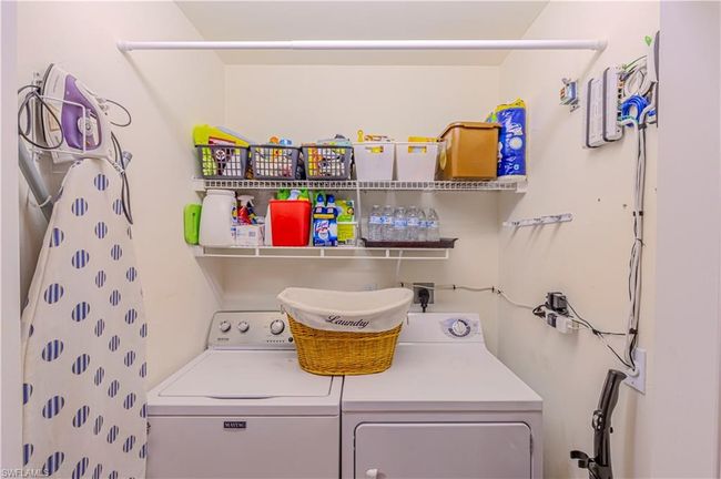 Ensuite Laundry area featuring washer and clothes dryer & storage racks | Image 29