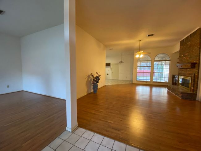 Unfurnished living room with light wood-style flooring, a ceiling fan, and a brick fireplace | Image 4