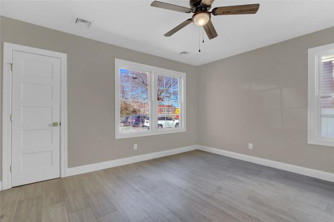Unfurnished room featuring a ceiling fan, baseboards, visible vents, and light wood finished floors | Image 8
