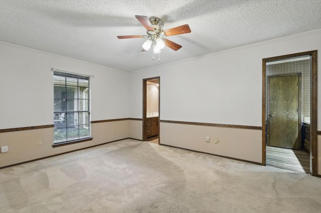 Empty room with a ceiling fan, carpet, a textured ceiling, and crown molding | Image 24