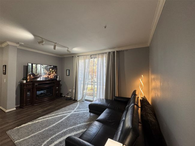 Living room featuring dark hardwood / wood-style flooring, crown molding, and track lighting | Image 4