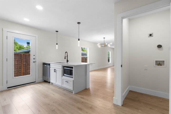Kitchen with appliances with stainless steel finishes, a peninsula, light wood-style floors, white cabinets, and recessed lighting | Image 19