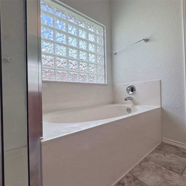 Bathroom featuring a garden tub and a textured wall | Image 15