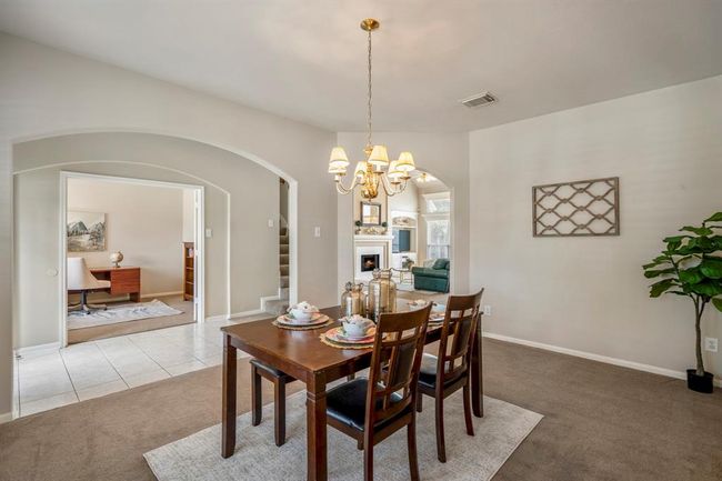 From the formal dining room, enjoy a seamless view across the foyer into the study, while the central archway offers a glimpse into the spacious family room beyond, highlighting the home’s open and connected layout. | Image 6