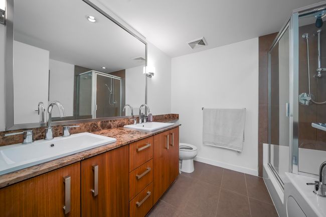 Bathroom featuring tile patterned flooring, visible vents, an enclosed shower, and a sink | Image 16