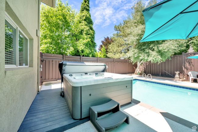 View of pool with a fenced backyard and a hot tub | Image 6