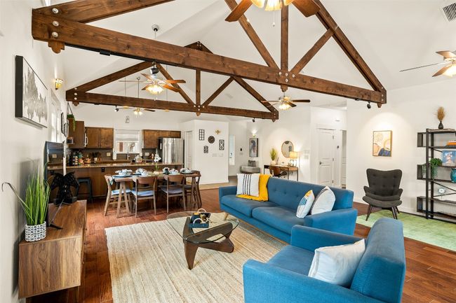 Living room with a ceiling fan, dark wood-style floors, beam ceiling, and high vaulted ceiling | Image 10