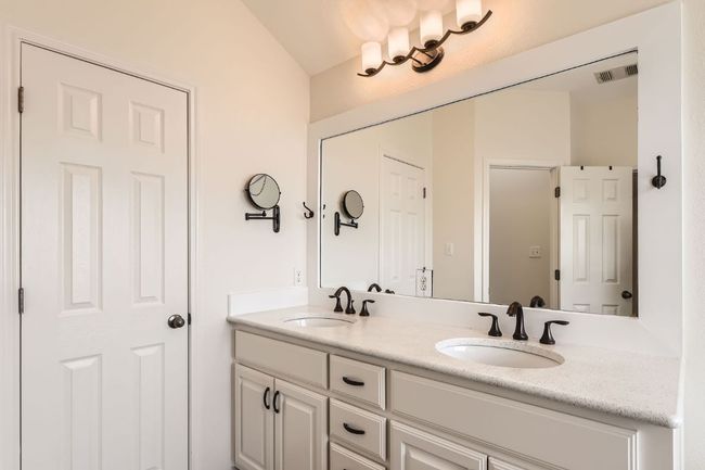Full bathroom featuring double vanity and lofted ceiling | Image 22