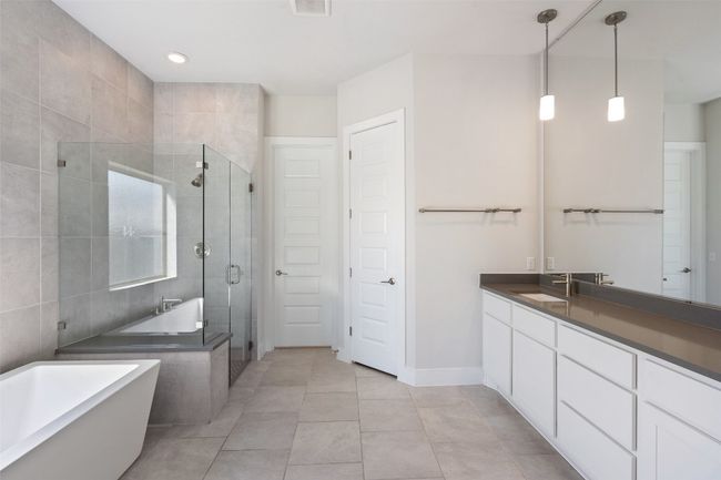 Full bathroom featuring a shower stall, a freestanding bath, vanity, and tile patterned floors | Image 19