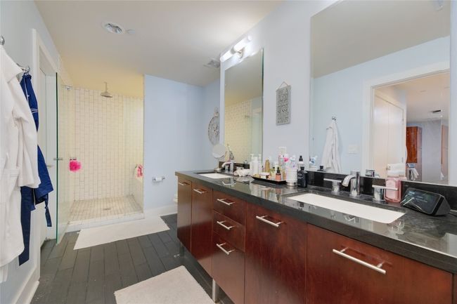 Bathroom with a stall shower, double vanity, and wood finished floors | Image 17