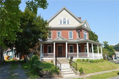 View of front of property featuring a porch and a front lawn | Image 1