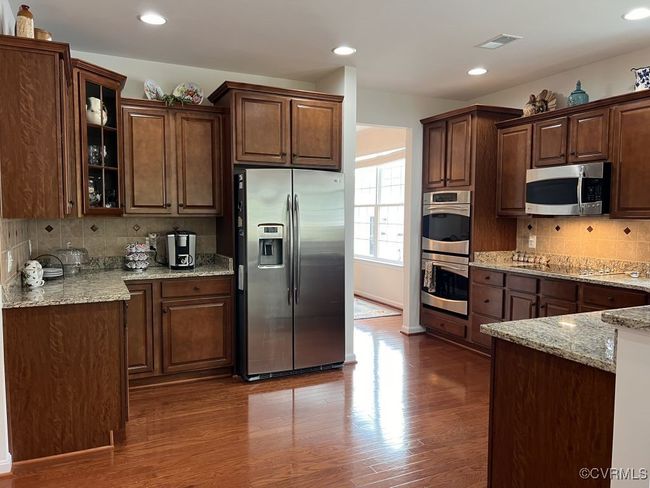 Kitchen featuring light stone countertops, stainless steel appliances, dark hardwood / wood-style floors, and decorative backsplash | Image 18