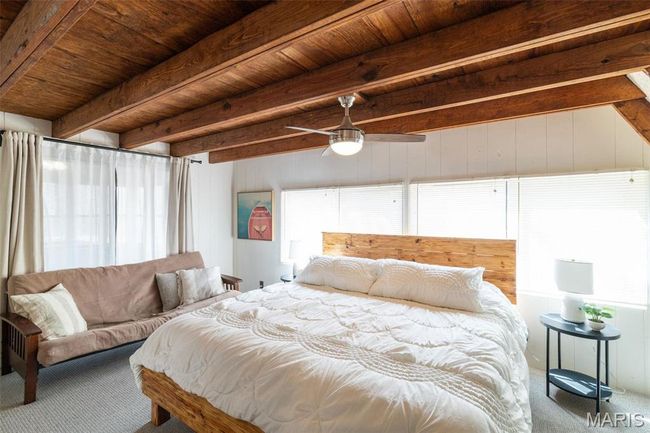 Carpeted bedroom featuring beamed ceiling, wood ceiling, and ceiling fan | Image 25