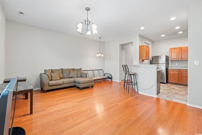 Living room with a chandelier, light wood-style floors, baseboards, and recessed lighting | Image 5