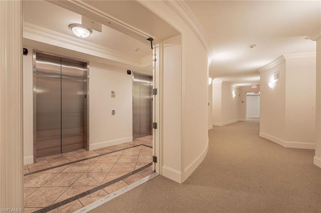 Hall with light colored carpet, elevator, and ornamental molding | Image 7